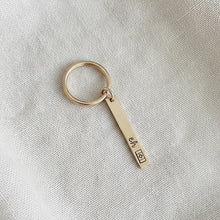 Gold keychain with engraved text  "eh" and a Canadian flag