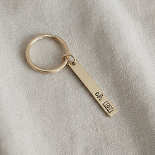 Gold keychain with a hand stamped tag "eh" Canadian flag